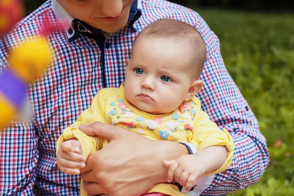 Daddy holds little daughter in her arms.