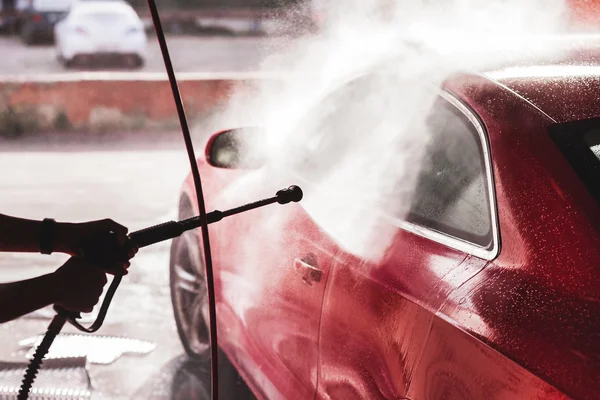 Woman washing a red sports car