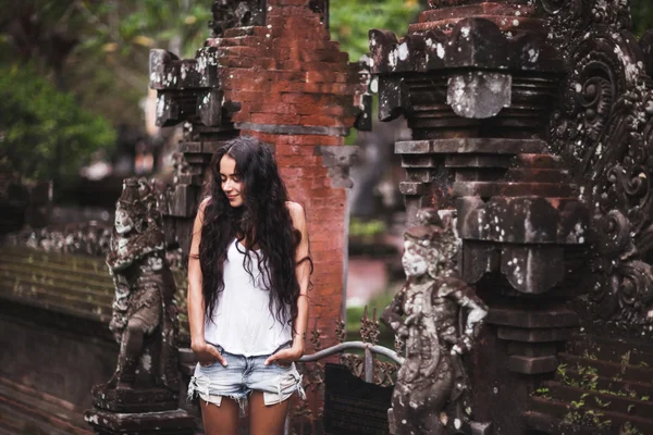 Young woman by an old Balinese architecture