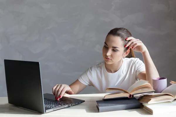 Girl behind the books reads prepares for exams