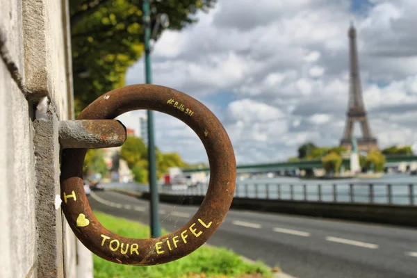 Eiffel Tower behind old rusted ring with I love Tour Eiffel word