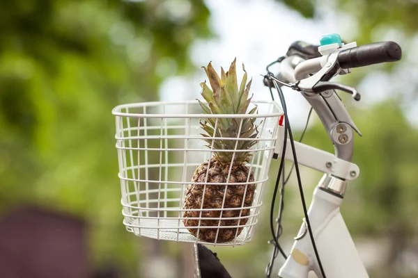 Pineapple in bike basket green blurred background bokeh