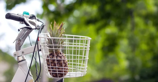 Pineapple in bike basket green blurred background bokeh