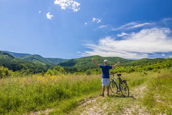 Young man standing near  bicycle in morning sunrise with wonderf