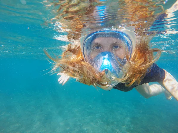 Red hair snorkeling girl close up portrait underwater