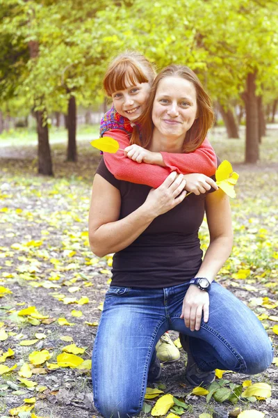 Mother and daughter enjoying weekend  in the autumn park