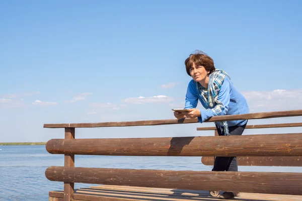 Woman resting on sea and uses tablet pc