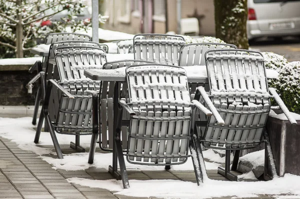 Chairs and tables covered by snow