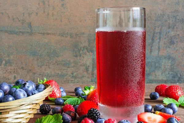 Fresh cold summer berries juice in a glass