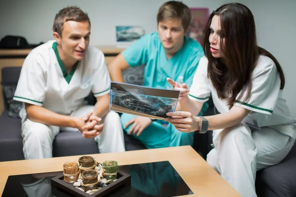 Dentist looking teeth on digital X-Ray.Health care,medical and radiology concept-group of doctors looking at x-ray,consulting with team about treatment