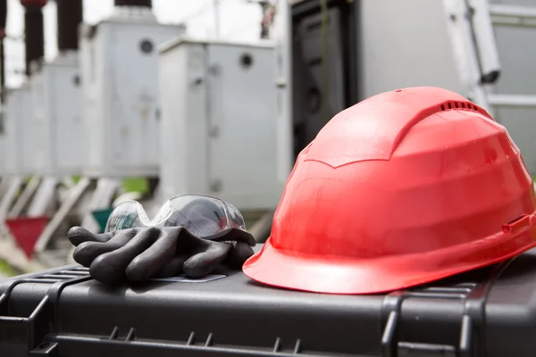 Hard hat,safety glasses and gloves on tool box.Safety gear kit close up,safety equipment for work outdoor at high voltage power substation,power plant.Safety for electricians at work