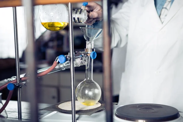 Scientific researcher doing a chemical experiment research.Science students working with chemicals. Chemist doing research with laboratory equipment. Pharmacist performing distillation process