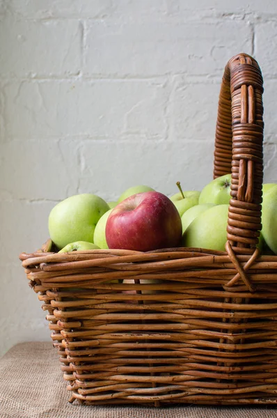 Red apple in basket of green apples (cropped)
