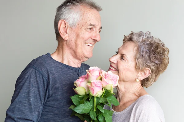 Older couple smiling with roses