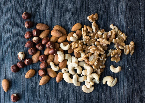 Nuts scattered on black background
