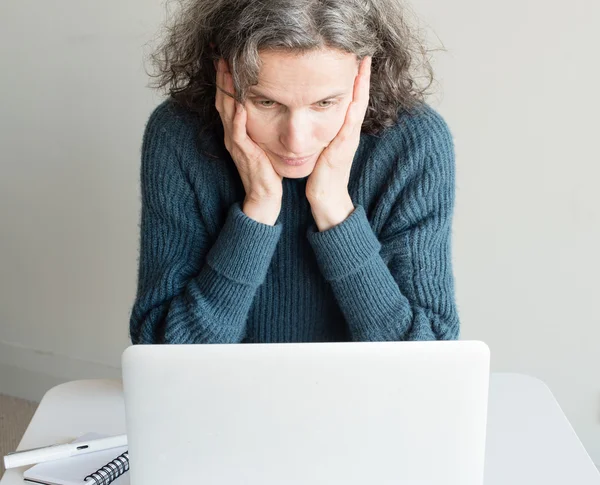 Frustrated middle aged woman with computer