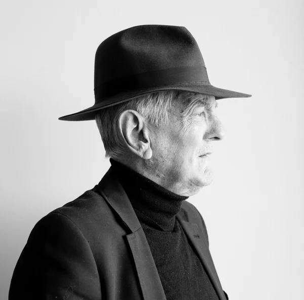 Profile of older man in black hat