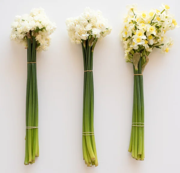 Three bunches of flowers on table from above