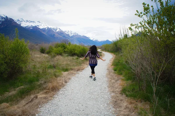 Happy and careless girl walking or skipping on a trail