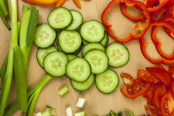 Freshly sliced English cucumber surrounded by other vegetables