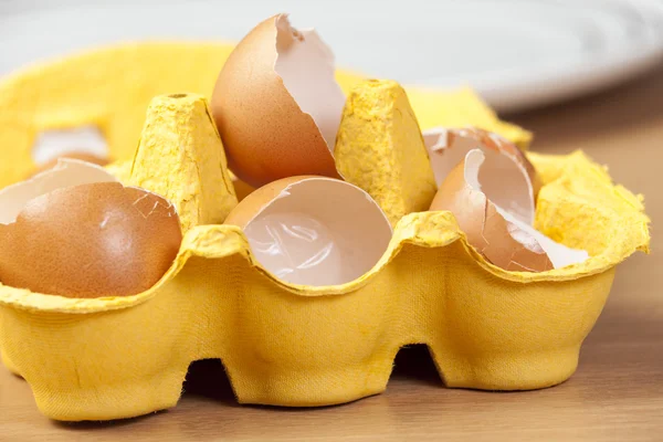 Yellow egg box full of broken egg shells