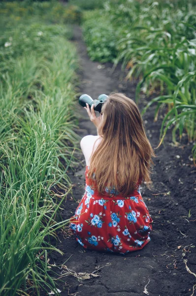 Beautiful woman looking up with binoculars.  Girl with binocular