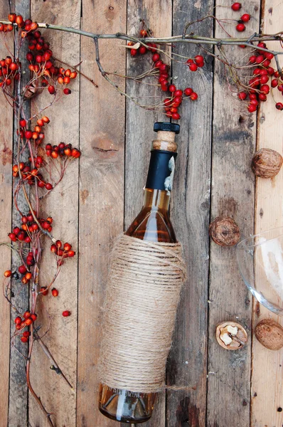 The still life with white wine in glass bottle on wood backgroun