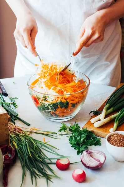 Woman on kitchen cuts vegetables for salad. Dieting and detox dr