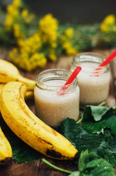 Fruit Smoothies. banana smoothies with milk. Banana Smoothie on a wooden table. Healthy breakfast: banana smoothie with oatmeal. Banana smoothie in glass with fresh fruits on wooden background