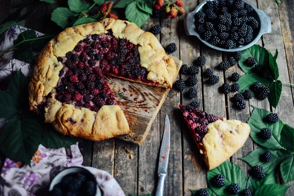 freshly baked berry pie. Blackberries pie with a slice missing.