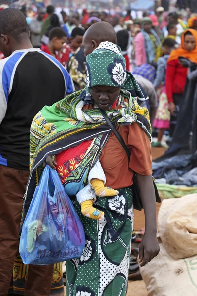 Portrait of African woman holding a baby at Karatu Iraqw Market, Tanzania.