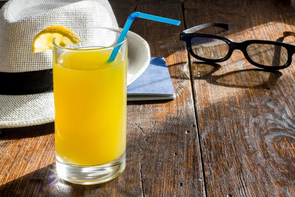 Glass of  juice with a summer hat and sunglasses