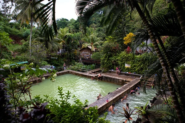 Bali, Indonesia - Mar 12, 2014 : People soak and relax in hot mineral waterfall