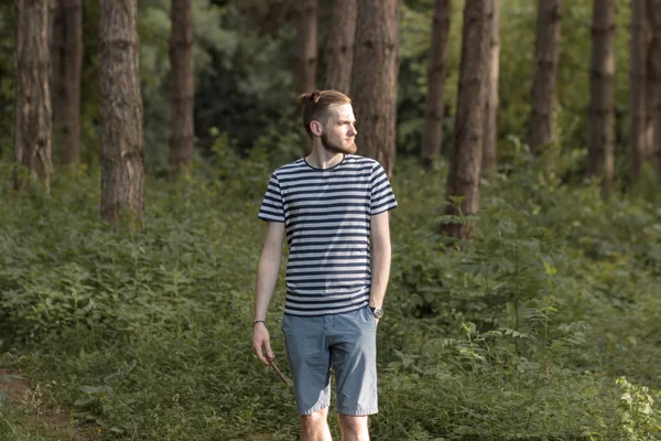 Young man walking in forest woods