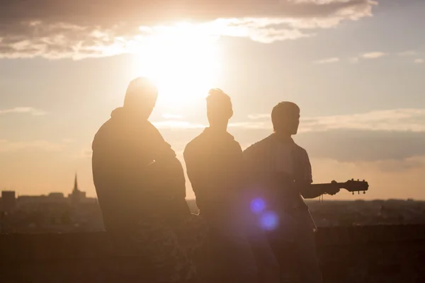 Three men music band guitar backlit Strong lens flare sunlight s