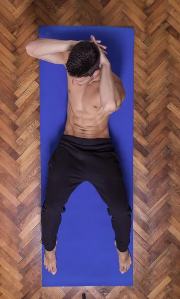 Young fit slim muscular sideway abs man exercise elevated view