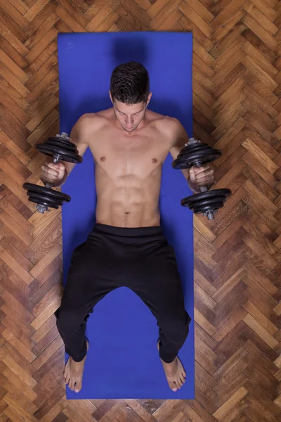 Young man abs dumbbell elevated view