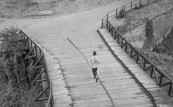Black and white one man run jogging elevated view rear back