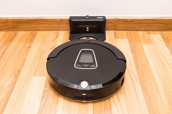 Robotic vacuum cleaner on wood parquet floor