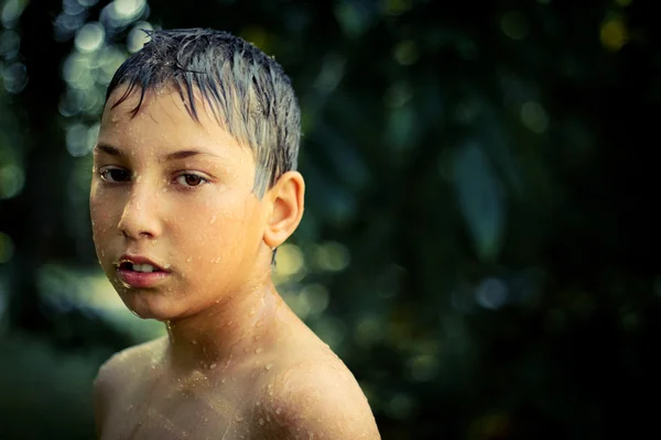 Boy after rain with drops of water face