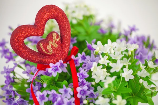 Heart, symbol of love in a bouquet  small flowers.