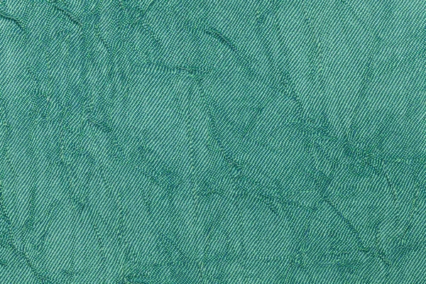 Light green pearl wavy background from a textile material. Fabric with natural texture closeup.
