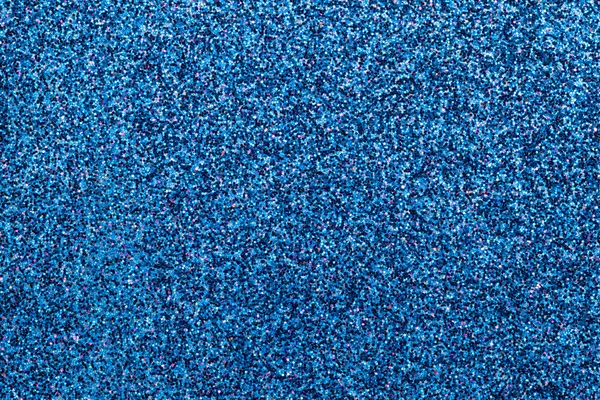 Sparkling background of blue sparkles closeup.
