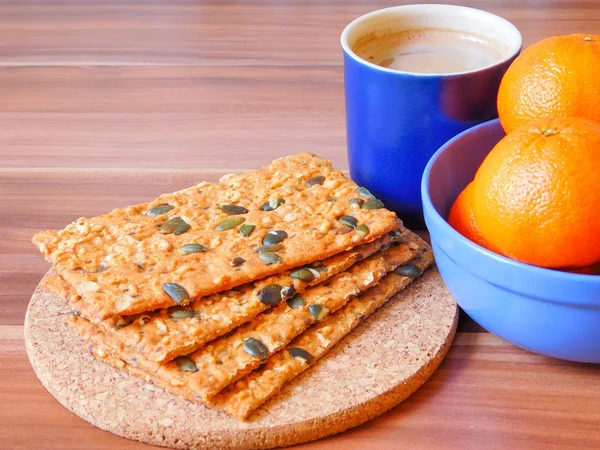 Snacks with seeds and nuts with cup of coffee and oranges