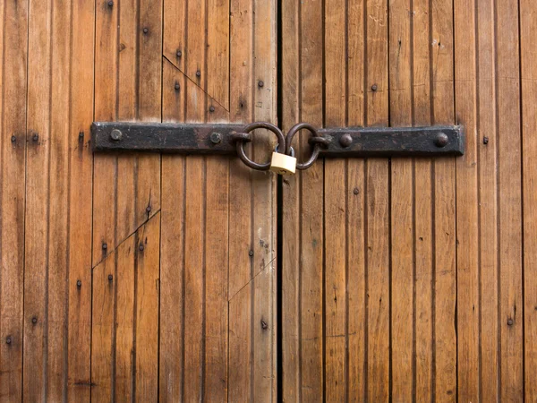 Padlock closing old wood door