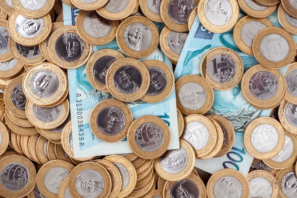 Brazilian 1 Real coins and 100 Reais bank notes