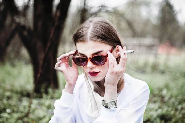 Portrait of a beautiful girl in a black coat on the nature