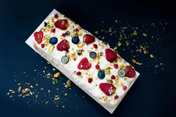 Cake with butter cream and raspberries on dark background