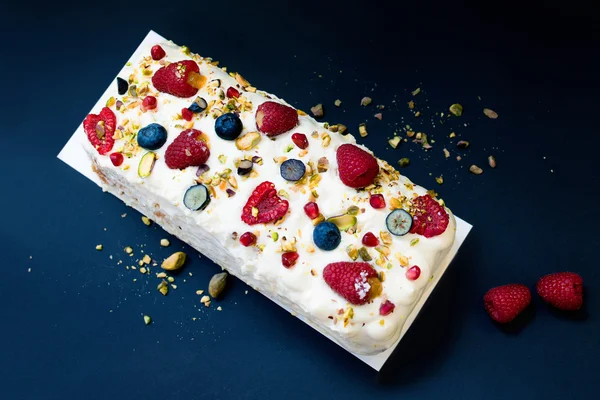 Cake with butter cream and raspberries on dark background