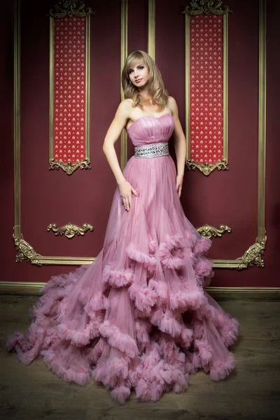 Portrait of young beautiful girl in long pink dress